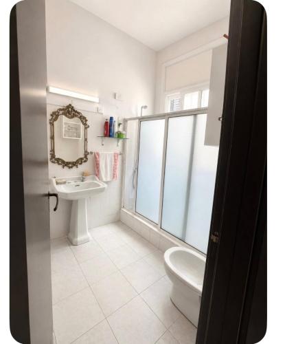 a bathroom with a toilet and a sink and a mirror at Le coin vert in Rabat
