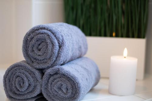 a pile of towels sitting next to a candle at Ferienwohnung Weiher - Nähe Nürnberg / Messe in Schwanstetten