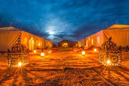 a group of tents in the desert at night at Sahara Starlight camp in Merzouga