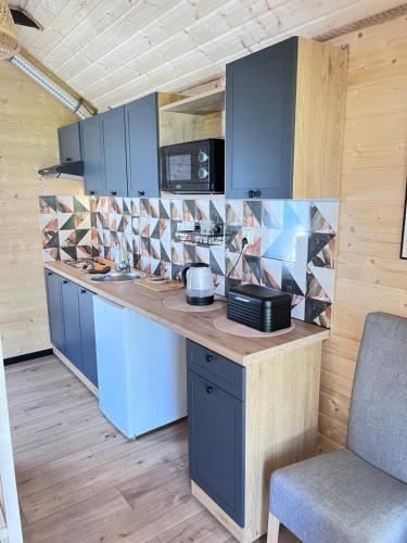 a kitchen with blue cabinets and a counter top at Domek Słoneczna in Mieroszyno
