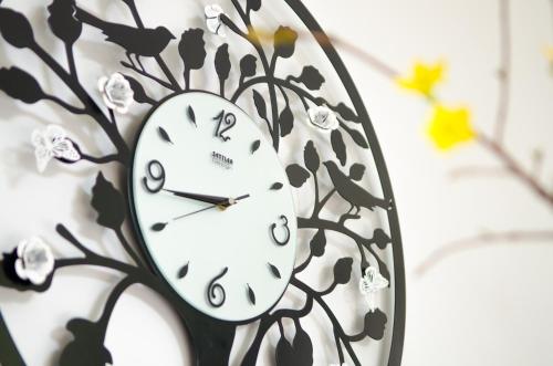 a clock with a tree design on a wall at Hotel Five.S in Kampot