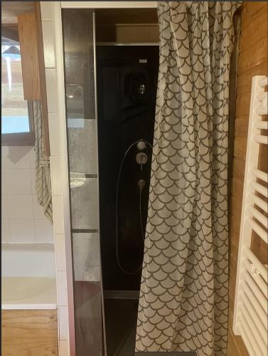a glass door with a shower in a bathroom at La petite maison sur la colline in Rue