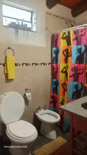 a bathroom with a toilet and a shower curtain at La Agraria in Junín