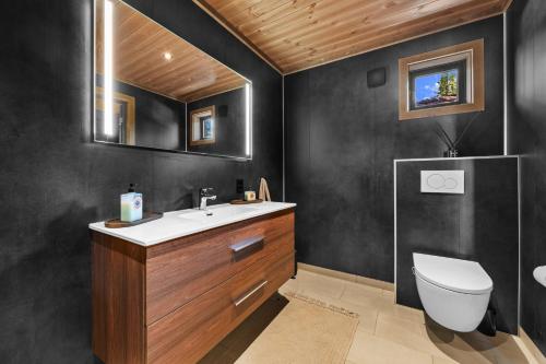 a bathroom with a toilet and a sink and a mirror at Reno Hytta in Eggedal