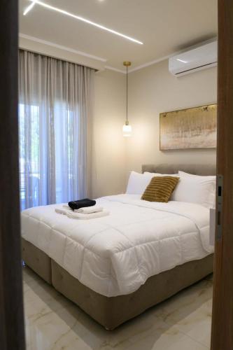 a bedroom with a large white bed with a window at Pella Luxury Archonta in Pélla