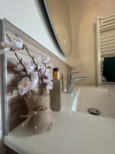 a vase of flowers sitting on a counter next to a sink at Les Iles d'ici in Rochefort