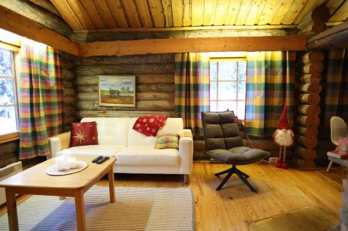 a living room with a white couch and a chair at Holidayhome Sompio in Luosto