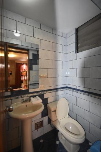 a bathroom with a toilet and a sink and a mirror at Fuente de Agua in Cusco
