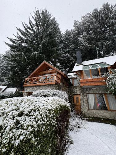 a house covered in snow in front at El Remanso del Lago in Villa La Angostura