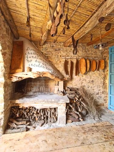 ein Zimmer mit Steinkamin und Holzdecke in der Unterkunft Sa Centenaria in Escalaplano
