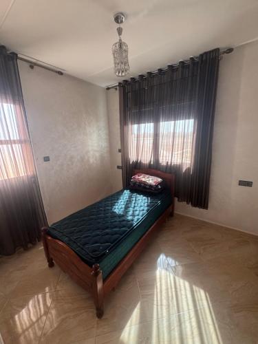 a bedroom with a bed in a room with windows at Apartment Selouane in Selouane