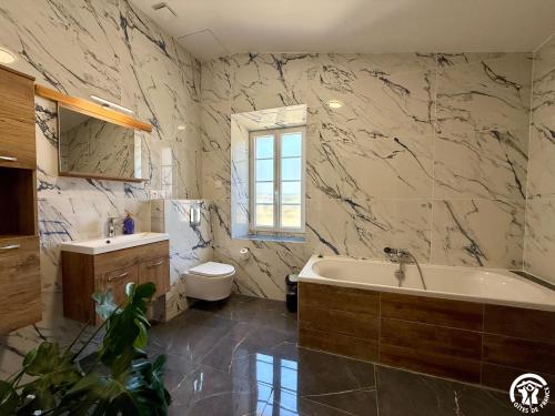 a bathroom with a tub and a toilet and a sink at Château de Prax Viel - piscine et mini ferme, climatisé in Lagrasse