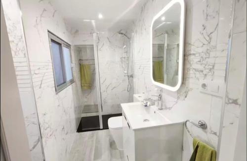 a white bathroom with a sink and a mirror at Casa reformada centro de Lliria in Lliria