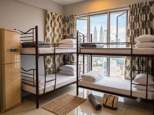 a room with three bunk beds with a window at Ehsan Suites in Kuala Lumpur