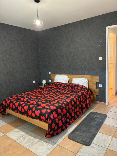 a bedroom with a large bed with a red blanket at maison bozouls in Bozouls