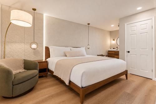 a bedroom with a large bed and a chair at Forest Springs Resort in Eureka Springs