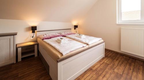a bedroom with a bed with white sheets and a window at Wellness apartmán Habánská in Pouzdřany