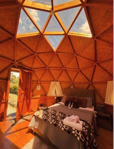 a bedroom in a yurt with a bed in it at GLAMCAPTOUR in Guatavita