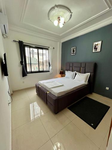 a bedroom with a bed and a window at Western Suites in Douala