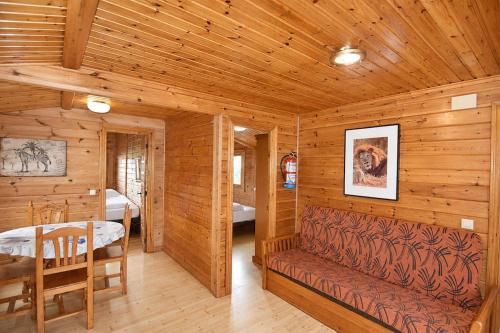 a log cabin with a bench and a dining room at Cabaña Las Cebras de Cabárceno in Penagos