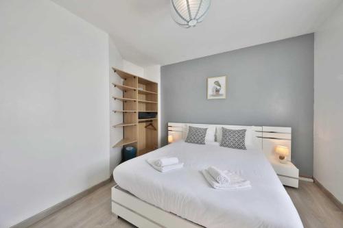 a bedroom with a white bed with two towels on it at Villa Fontenailles in Mâcon