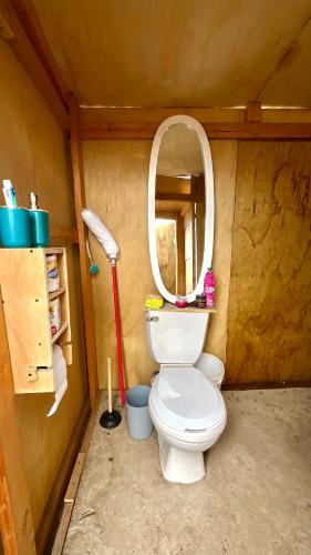 ein kleines Badezimmer mit einer Toilette mit Spiegel in der Unterkunft Solara Glamping in Tecate