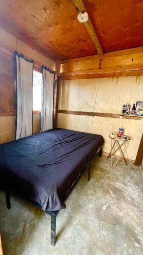 ein Schlafzimmer mit einem Bett in einem Holzzimmer in der Unterkunft Solara Glamping in Tecate