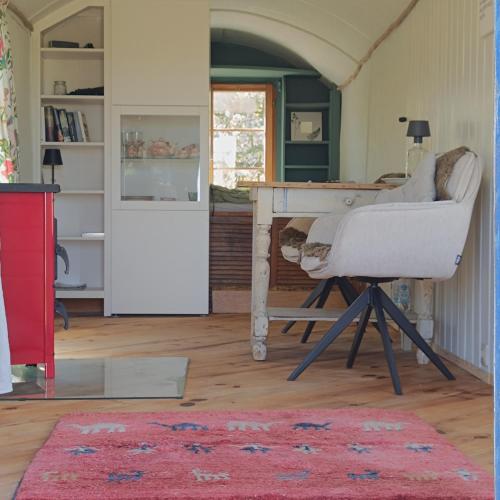a living room with a desk and a chair at Bauwagen Fridolin in Restorf