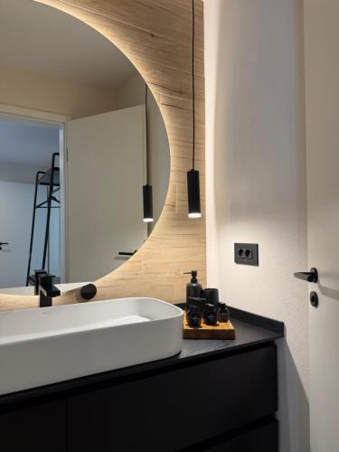 a bathroom with a white sink and a mirror at Akacia Chalet in Moieciu de Jos