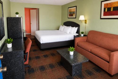 a hotel room with a bed and a couch at Seminole Inn in Donalsonville