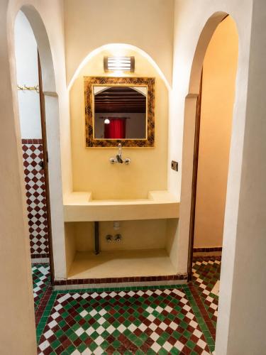 a bathroom with a sink and a mirror at Camels House in Merzouga