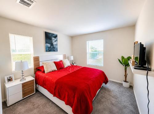 a bedroom with a red bed and a tv at Route 66 Desert Retreat 3 Bedroom Home With Garden in Victorville