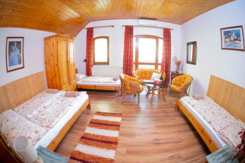 a room with three beds and a table and chairs at Vicze Apartmanház in Siófok