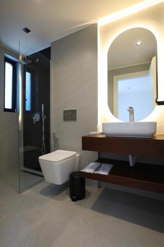 a bathroom with a sink and a toilet and a mirror at Zeo Hotel Saranda in Sarandë