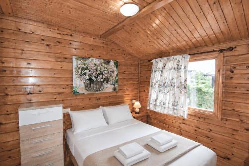 a bedroom with a bed in a wooden room at Cabaña Los Leones de Cabárceno in Penagos