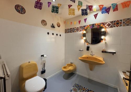 a bathroom with a toilet and a sink and a mirror at Ciné Lodge Lourdes in Lourdes