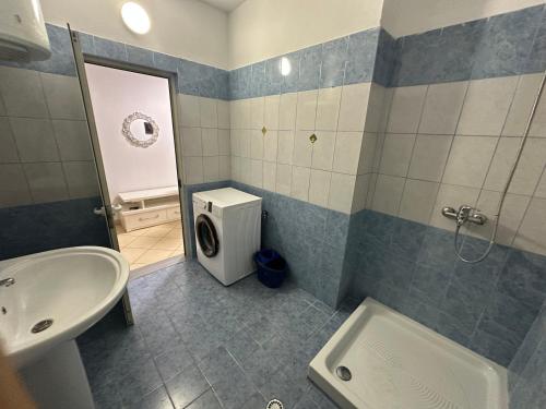 a bathroom with a sink and a washing machine at Bledis Apartments in Lushnjë