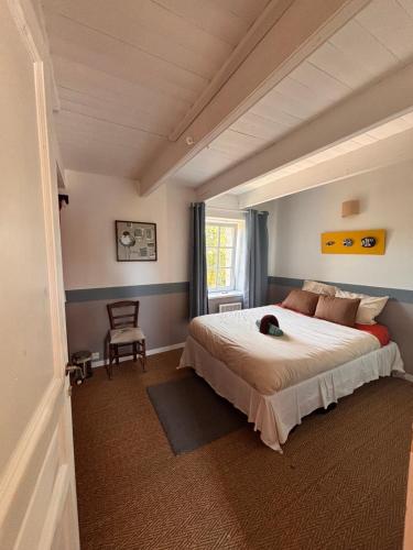 a bedroom with a large bed and a chair at Chambres Kergana in Landéda