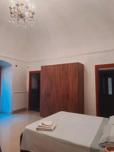 a bedroom with a bed and a cabinet and a chandelier at B&B Rosy in Corato