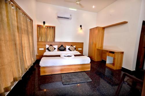 a bedroom with a large bed and a desk at MT'S Villas in Batheri