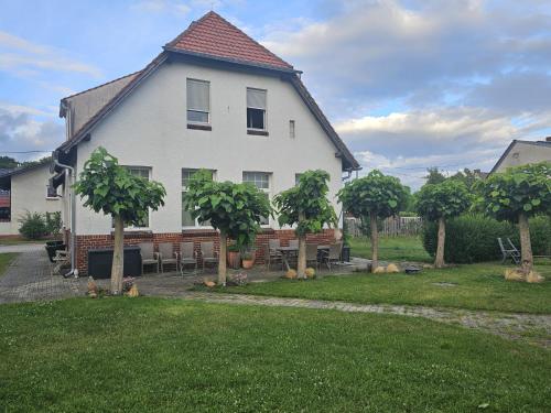 a large white house with tables and chairs in a yard at Alte Schule Ragow in Ragow