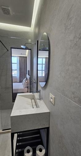 a bathroom with a sink and a mirror at The Center 104 in Polisi i Vogël