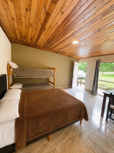 a bedroom with a bed with a wooden ceiling at Complejo La Cascada San Javier in San Javier
