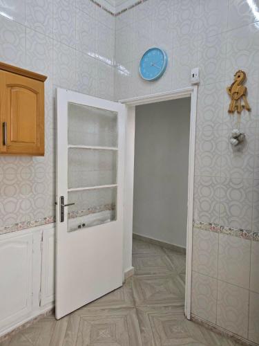ein Zimmer mit einer Tür und einer Uhr an der Wand in der Unterkunft Ariam in Annaba