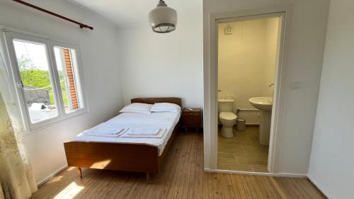 a bedroom with a bed and a bathroom with a window at Avdera Holidays apartments in Ávdhira