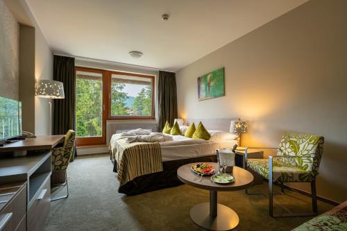 a hotel room with a bed and a table at Hotel Bystrá in Brezno