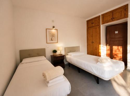 a room with two beds and a table with a lamp at Hostal la calma de Mascaraque in Mascaraque