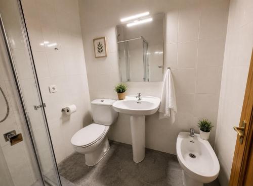 a white bathroom with a toilet and a sink at Hostal la calma de Mascaraque in Mascaraque