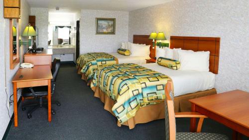a hotel room with two beds and a desk at Magnuson Hotel Howell/Brighton in Howell