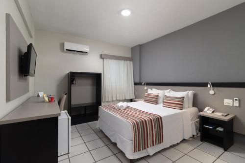 a hotel room with a bed and a television at Hotel Nacional Inn Recife Aeroporto in Recife